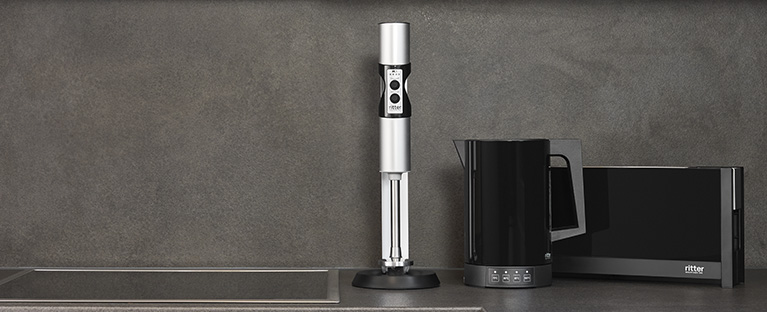 A picture of a hand blender, kettle and toaster in a dark kitchen