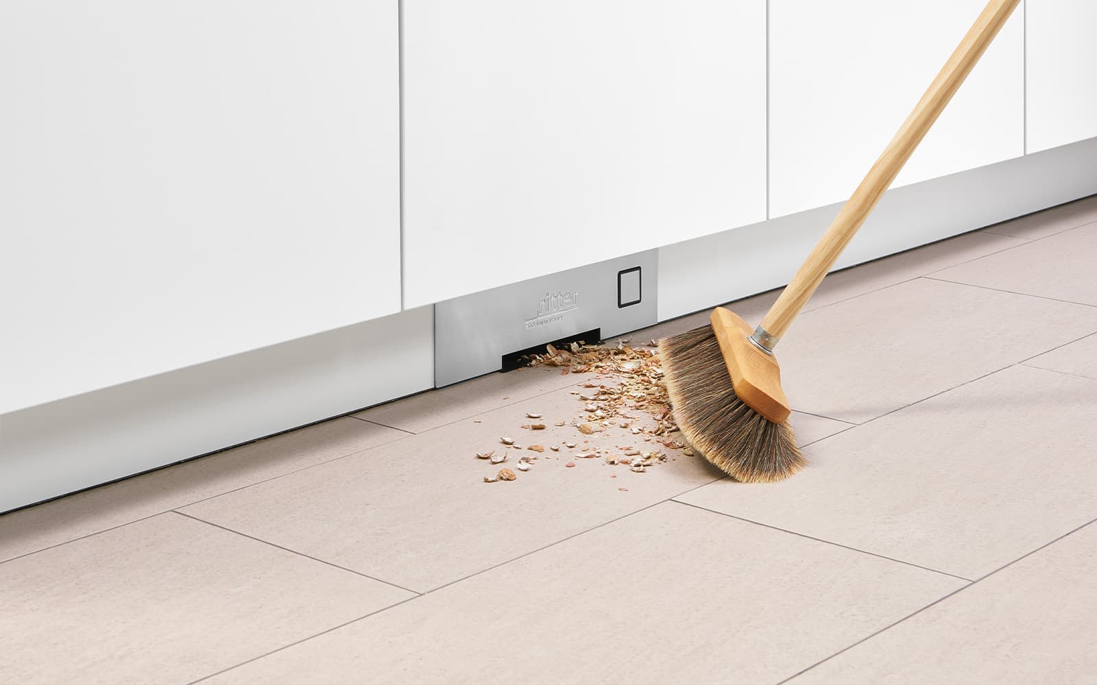 A broom that sweeps crumbs to the built-in upright vacuum cleaner.