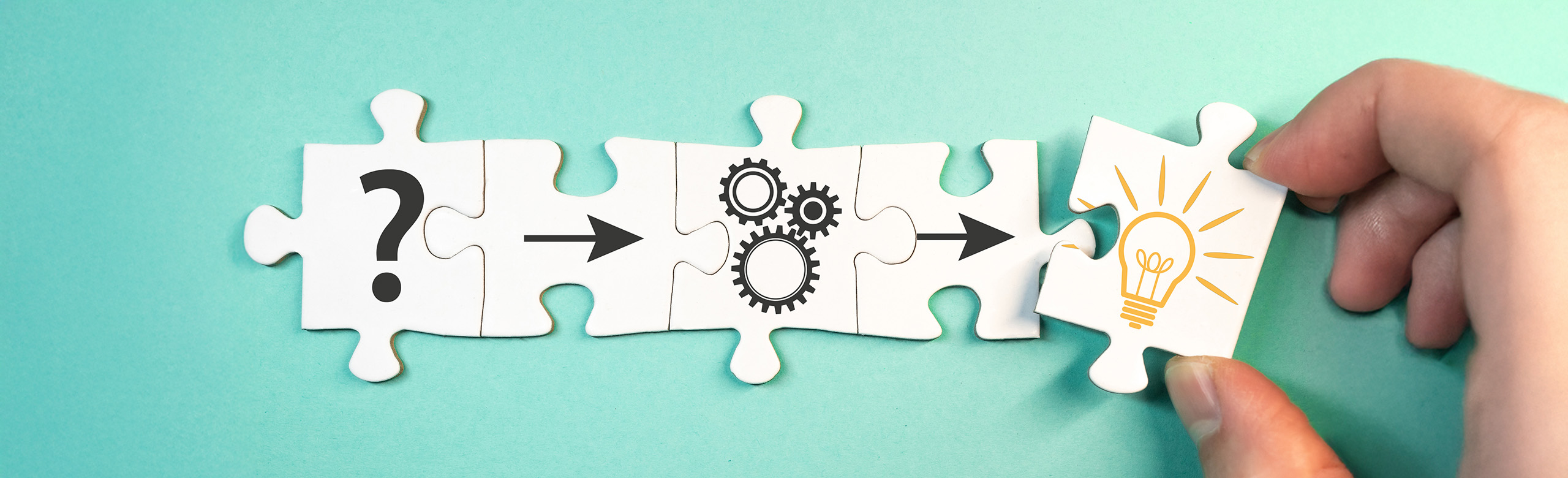 Innovations-Champions Five puzzle pieces and one of them is held by a hand