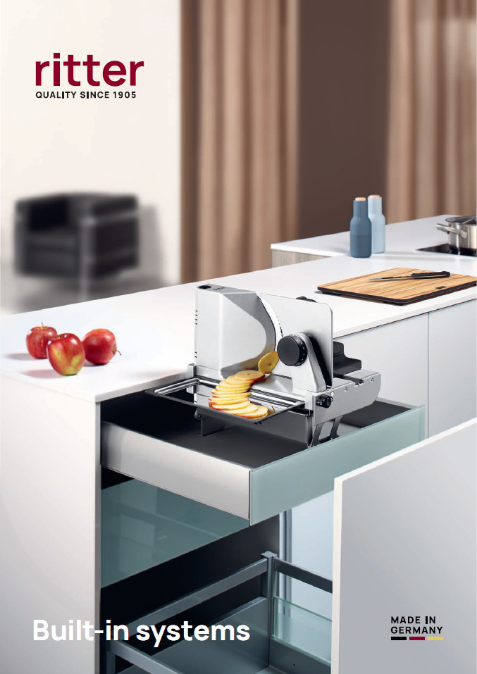 A picture from the cover of an English catalog showing a built-in all-purpose slicer slicing an apple and emerging from a kitchen drawer.