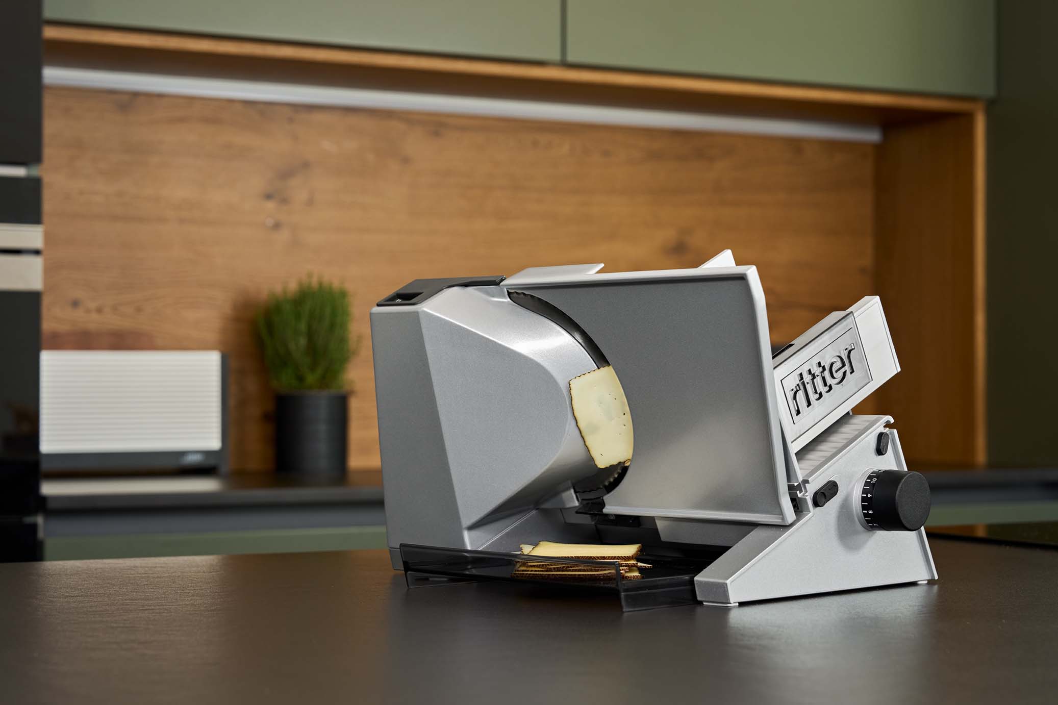 Elektrischer Allesschneider mit geschnittenem Käse, in moderner Küche