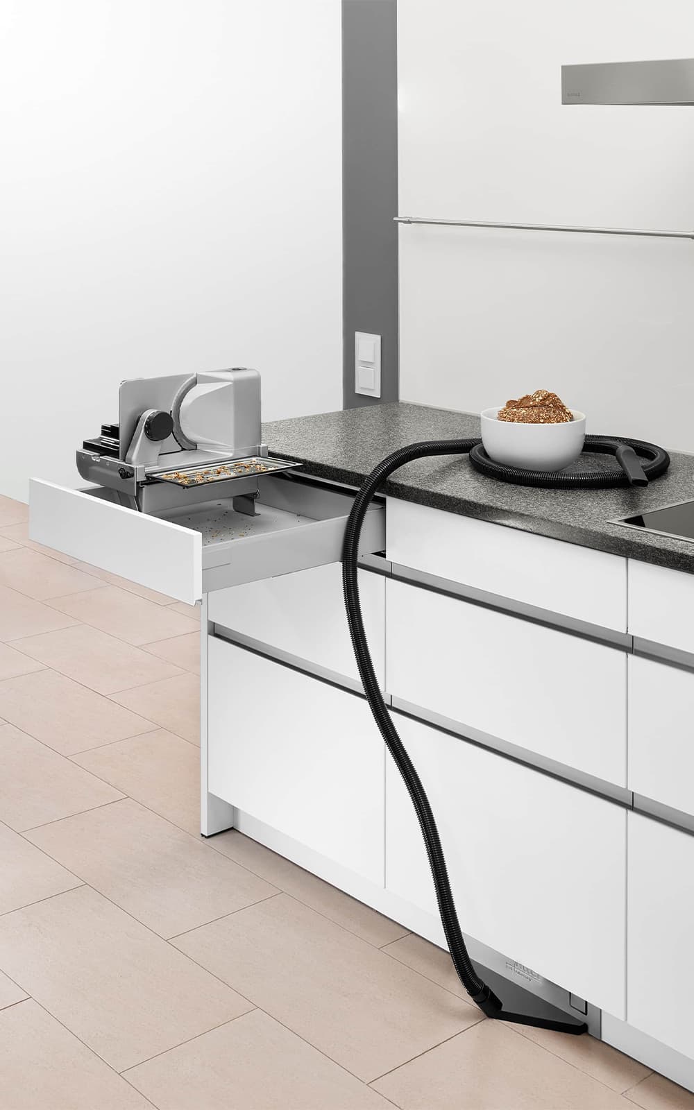 Built-in vacuum cleaner and built-in all-purpose slicer in a modern kitchen Built-in vacuum cleaner and built-in all-purpose slicer in a modern kitchen
