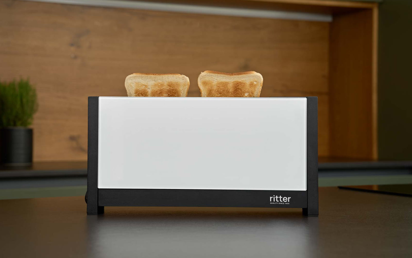 A picture of a white toaster toasting sandwiches and standing on a kitchen platform.