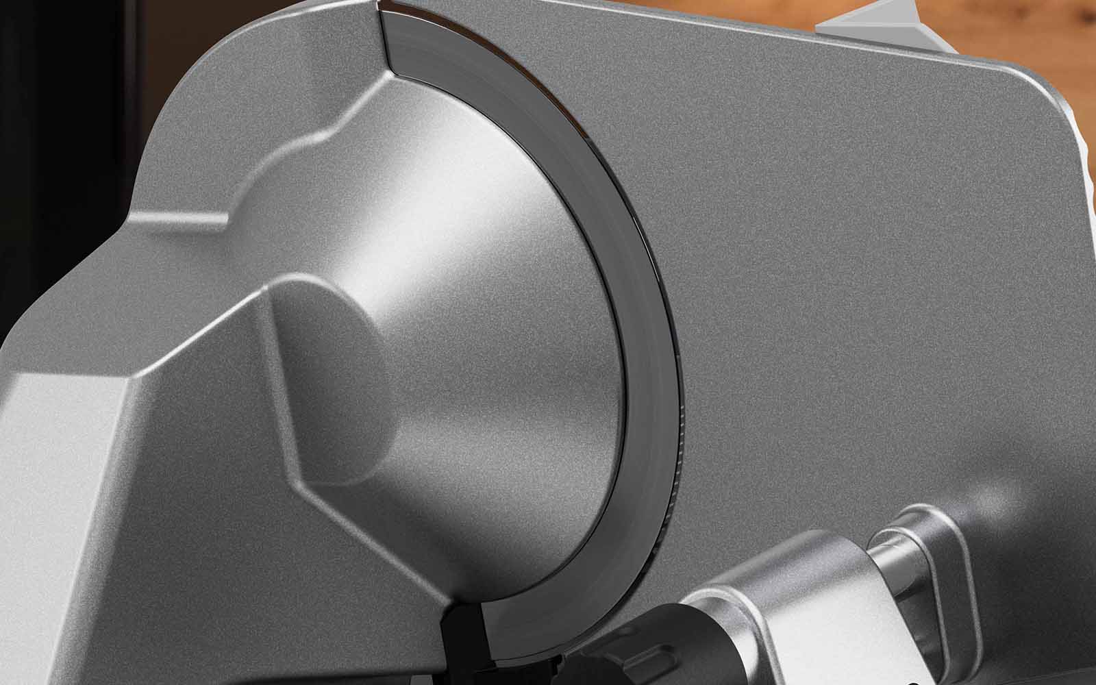Silver motor head of the deli slicer with attached blade.